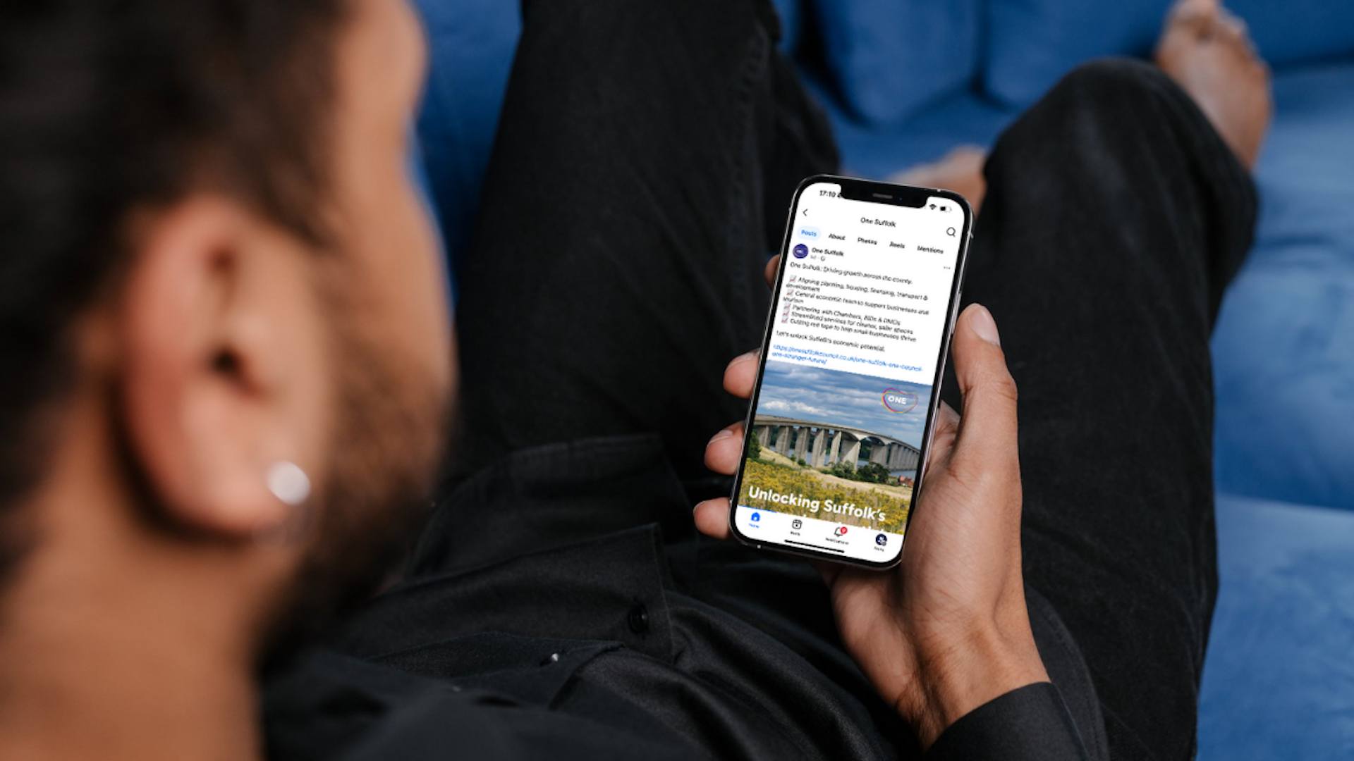 A man viewing a post on the One Suffolk Facebook page